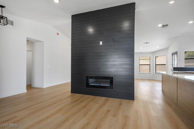 4319 Basil Leaf Ave, North Las Vegas, NV 89031 - unfurnished living room featuring light wood-type flooring, a large fireplace, recessed lighting, and lofted ceiling