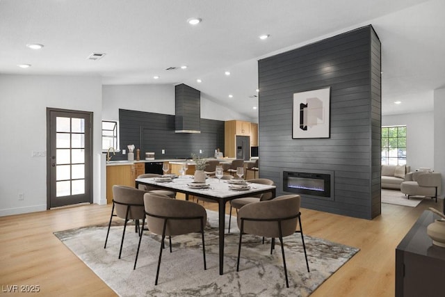 4319 Basil Leaf Ave, North Las Vegas, NV 89031 - dining space featuring light wood finished floors, a large fireplace, recessed lighting, and high vaulted ceiling