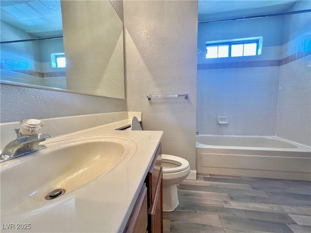 2627 S Durango Dr Unit 202, Las Vegas, NV 89117 - bathroom featuring a textured wall, wood finished floors, vanity, and shower / bath combination
