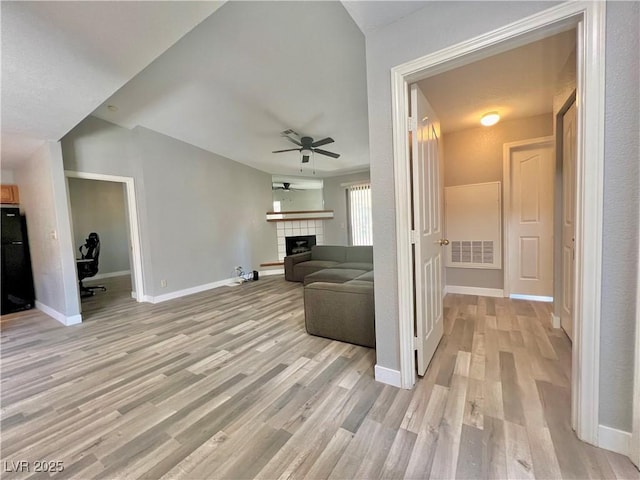 2627 S Durango Dr Unit 202, Las Vegas, NV 89117 - unfurnished living room with a ceiling fan, light wood-style floors, and a tiled fireplace