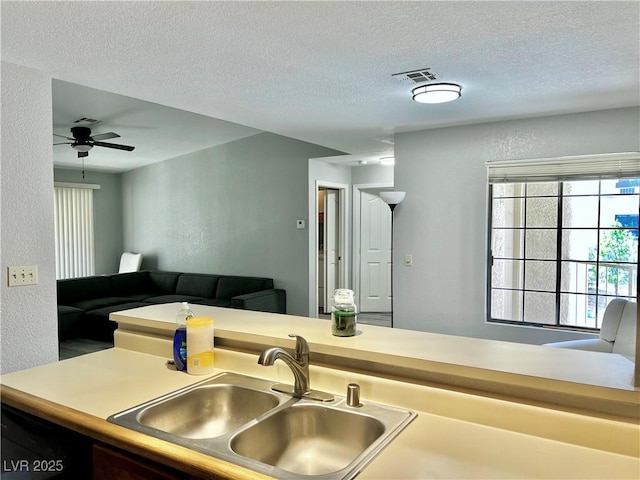 2627 S Durango Dr Unit 202, Las Vegas, NV 89117 - kitchen with a textured wall, a textured ceiling, a ceiling fan, and open floor plan