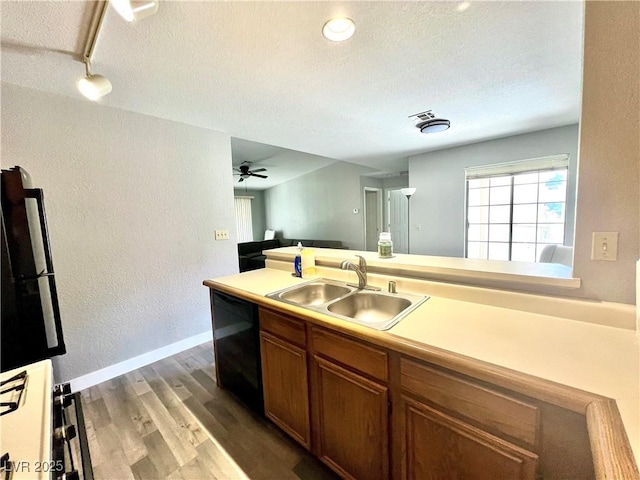 2627 S Durango Dr Unit 202, Las Vegas, NV 89117 - kitchen featuring wood finished floors, black dishwasher, light countertops, a textured ceiling, and brown cabinets