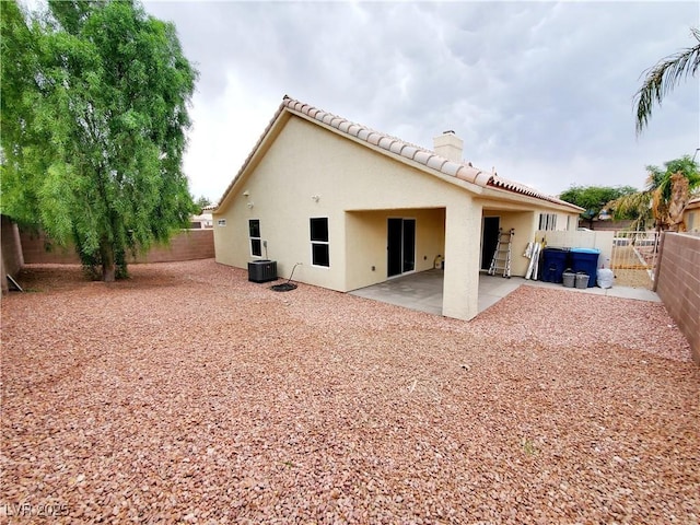 5104 Brookmere Dr, Las Vegas, NV 89130 - back of house featuring stucco siding, a fenced backyard, a chimney, a patio area, and a tiled roof