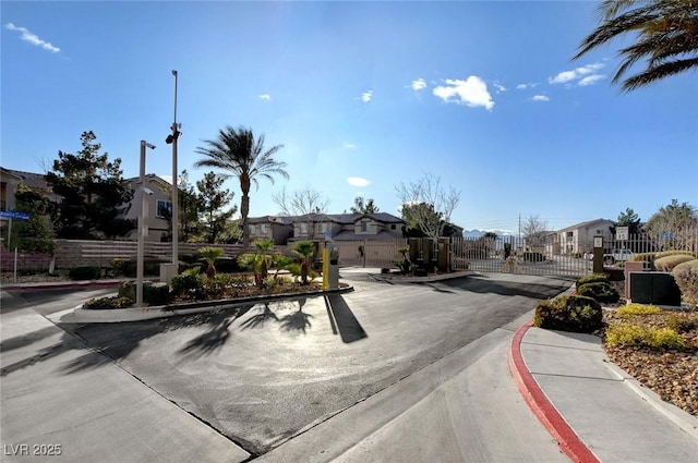 4610 Puglia Ln Unit 201, North Las Vegas, NV 89084 - view of asphalt street with a residential view, a gate, curbs, street lights, and a gated entry
