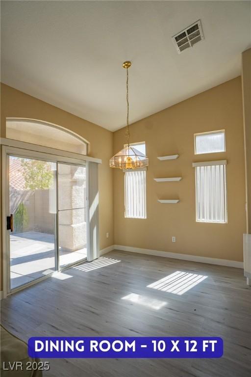 9710 Geiger Peak Ct, Las Vegas, NV 89148 - unfurnished dining area with wood finished floors, a chandelier, and lofted ceiling