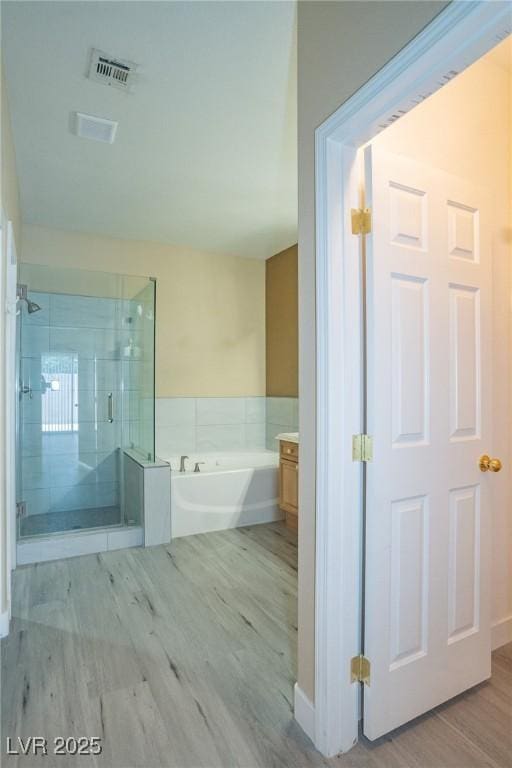 9710 Geiger Peak Ct, Las Vegas, NV 89148 - full bathroom featuring a bath, a shower stall, and wood finished floors