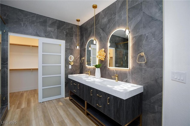 85 Alerion St, Las Vegas, NV 89138 - full bathroom featuring double vanity, wood finished floors, a shower, tile walls, and a walk in closet