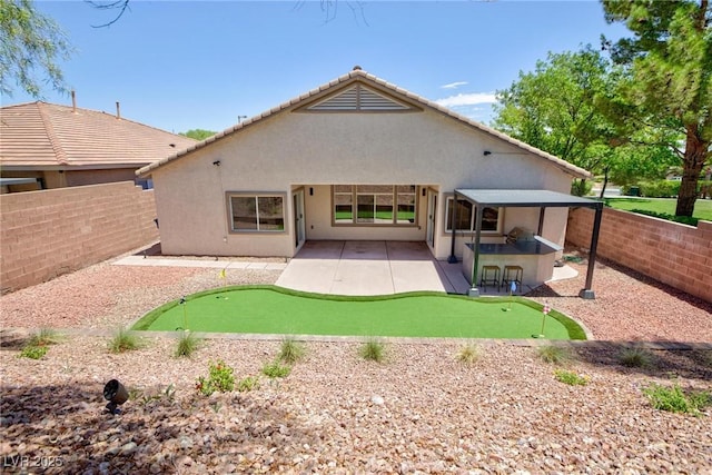 85 Alerion St, Las Vegas, NV 89138 - rear view of property featuring an area to practice putting, a patio, a fenced backyard, and stucco siding