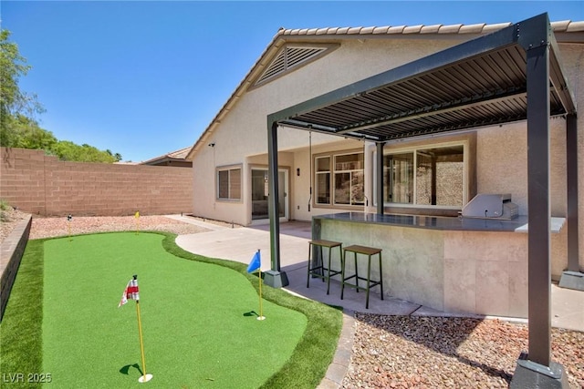 85 Alerion St, Las Vegas, NV 89138 - rear view of property featuring stucco siding, an outdoor bar, a patio, an area to practice putting, and exterior kitchen