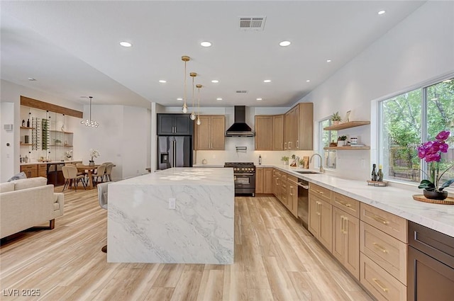 85 Alerion St, Las Vegas, NV 89138 - kitchen with appliances with stainless steel finishes, wall chimney exhaust hood, open shelves, a center island, and light stone counters