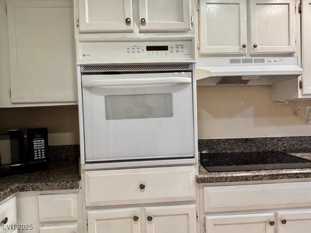 750 S Royal Crest Cir Unit 325, Las Vegas, NV 89169 - kitchen with black appliances, under cabinet range hood, dark countertops, and white cabinetry