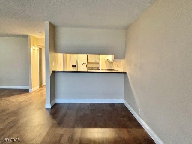 750 S Royal Crest Cir Unit 325, Las Vegas, NV 89169 - kitchen featuring white fridge with ice dispenser, wood finished floors, and a textured ceiling