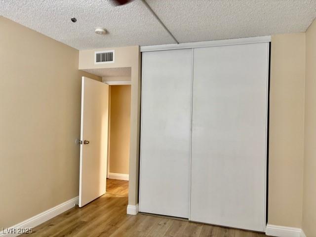 750 S Royal Crest Cir Unit 325, Las Vegas, NV 89169 - unfurnished bedroom featuring a closet and wood finished floors