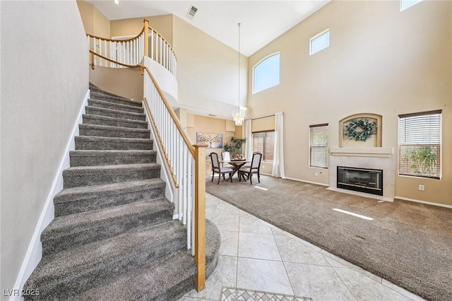 5434 Lost Ln, Las Vegas, NV 89118 - stairs featuring carpet flooring, a high ceiling, tile patterned flooring, and a tile fireplace