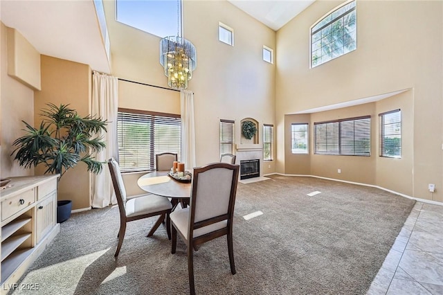 5434 Lost Ln, Las Vegas, NV 89118 - carpeted dining room with healthy amount of natural light, a chandelier, a fireplace with flush hearth, a high ceiling, and tile patterned floors