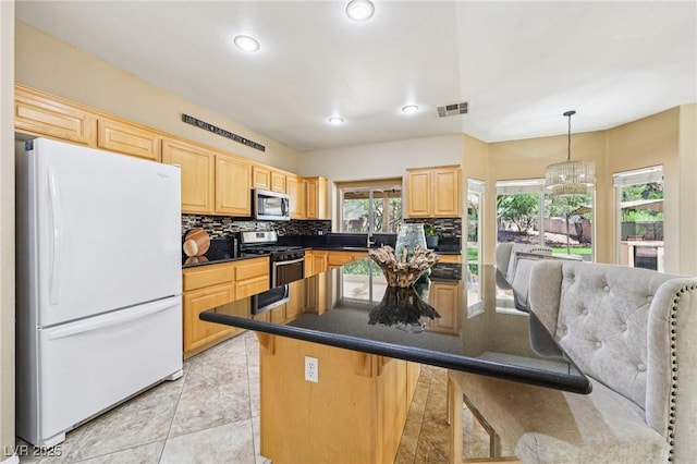 5434 Lost Ln, Las Vegas, NV 89118 - kitchen with appliances with stainless steel finishes, light brown cabinetry, tasteful backsplash, recessed lighting, and a kitchen bar