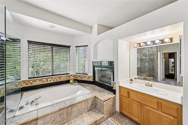 5434 Lost Ln, Las Vegas, NV 89118 - full bathroom featuring a garden tub, vanity, a shower stall, and a tiled fireplace