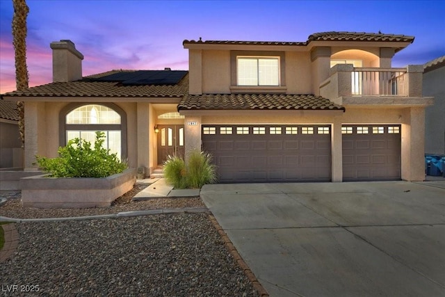 2842 Via Florentine St, Henderson, NV 89074 - mediterranean / spanish-style house with a tiled roof, an attached garage, solar panels, a balcony, and a chimney
