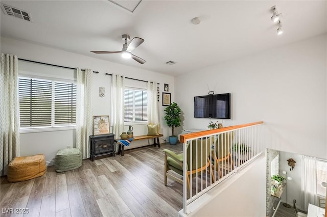 10372 Natural Springs Ave, Las Vegas, NV 89129 - living room with wood finished floors, a wood stove, and a ceiling fan