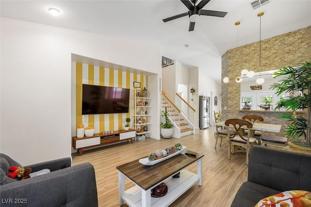 10372 Natural Springs Ave, Las Vegas, NV 89129 - living room featuring ceiling fan, wood finished floors, high vaulted ceiling, and stairs