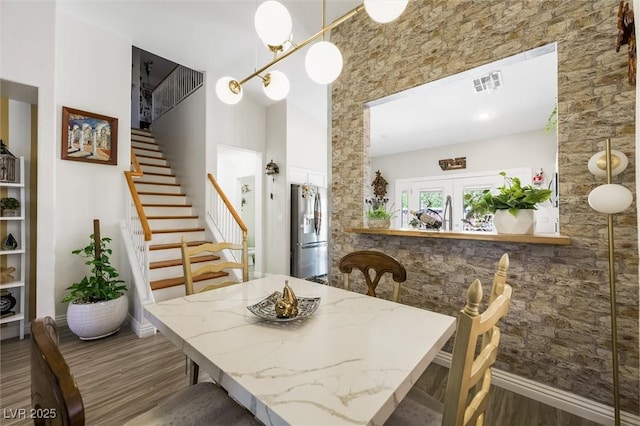 10372 Natural Springs Ave, Las Vegas, NV 89129 - dining area with stairway, wood finished floors, and a towering ceiling