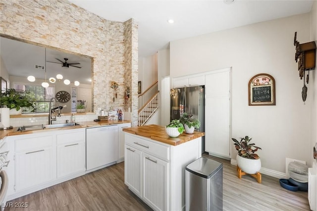 10372 Natural Springs Ave, Las Vegas, NV 89129 - kitchen featuring white dishwasher, butcher block counters, light wood finished floors, ceiling fan, and backsplash
