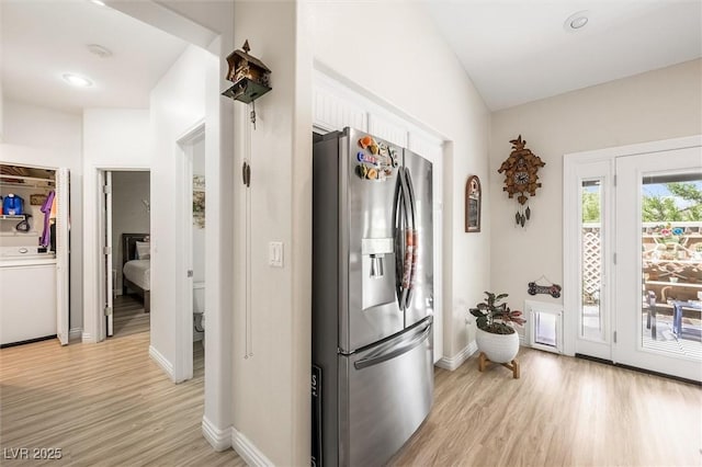 10372 Natural Springs Ave, Las Vegas, NV 89129 - kitchen with stainless steel fridge with ice dispenser, light wood finished floors, white cabinetry, and washer / clothes dryer
