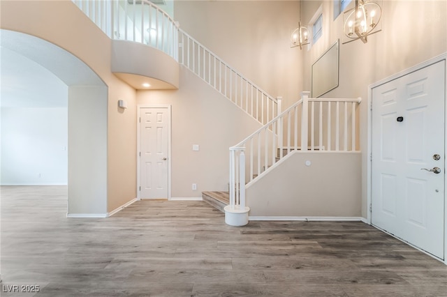 9578 Teton Vista Ave, Las Vegas, NV 89117 - entryway featuring a high ceiling, arched walkways, wood finished floors, and stairway