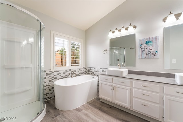 9578 Teton Vista Ave, Las Vegas, NV 89117 - bathroom with double vanity, a stall shower, tile walls, lofted ceiling, and wood finished floors