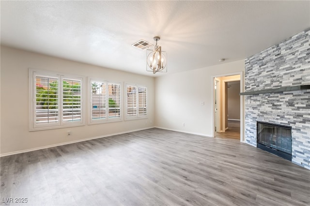 9578 Teton Vista Ave, Las Vegas, NV 89117 - unfurnished living room with a chandelier, wood finished floors, and a large fireplace