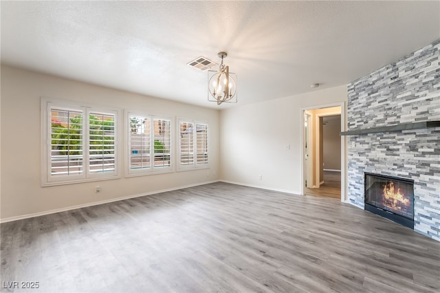 9578 Teton Vista Ave, Las Vegas, NV 89117 - unfurnished living room featuring a chandelier, wood finished floors, and a large fireplace