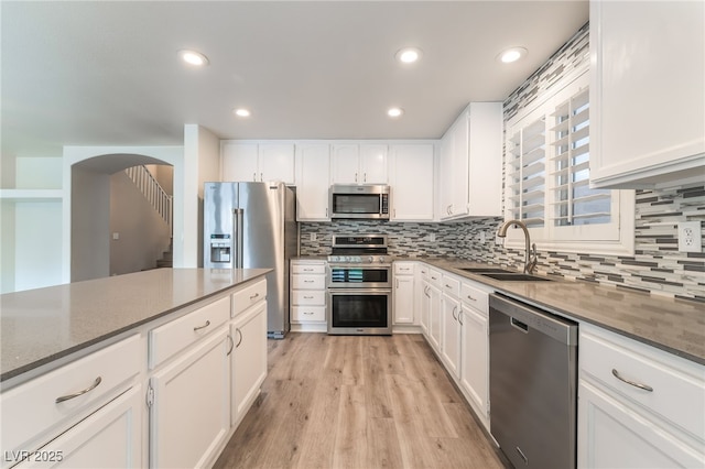9578 Teton Vista Ave, Las Vegas, NV 89117 - kitchen featuring stainless steel appliances, backsplash, white cabinetry, light wood-style floors, and recessed lighting