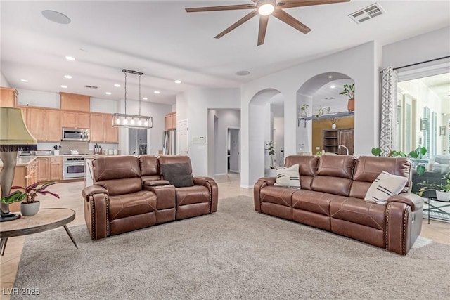 1521 Antler Creek St, North Las Vegas, NV 89084 - living room featuring ceiling fan, light tile patterned flooring, arched walkways, recessed lighting, and light colored carpet