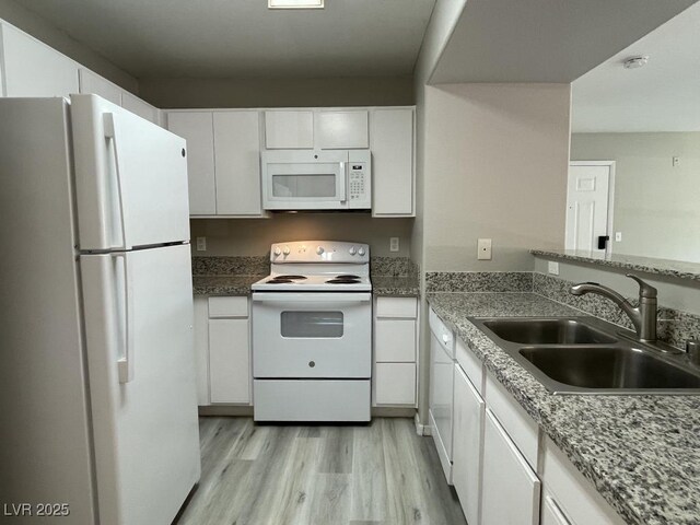 2300 E Silverado Ranch Blvd Unit 1180, Las Vegas, NV 89183 - kitchen with white appliances, light wood-type flooring, and white cabinets