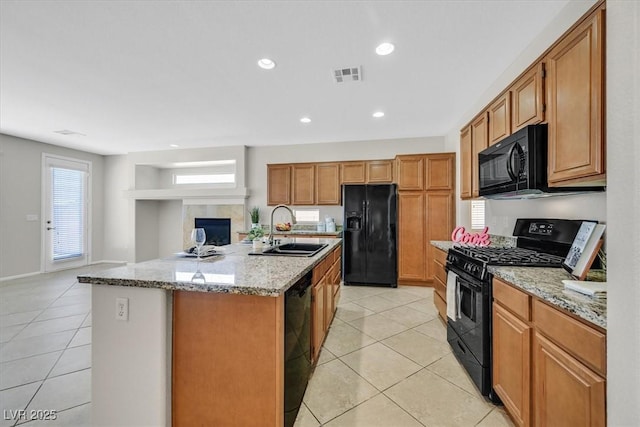 7558 Schuders Ave, Las Vegas, NV 89178 - kitchen featuring black appliances, light tile patterned floors, an island with sink, light stone counters, and recessed lighting