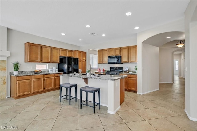 7558 Schuders Ave, Las Vegas, NV 89178 - kitchen with black appliances, arched walkways, light tile patterned floors, plenty of natural light, and recessed lighting