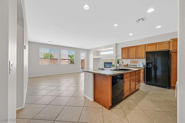 7558 Schuders Ave, Las Vegas, NV 89178 - kitchen with black appliances, open floor plan, brown cabinets, light tile patterned floors, and recessed lighting