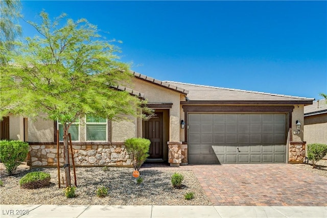 138 Red Sandstone Ave, North Las Vegas, NV 89031 - view of front of house featuring an attached garage, decorative driveway, stone siding, stucco siding, and a tile roof