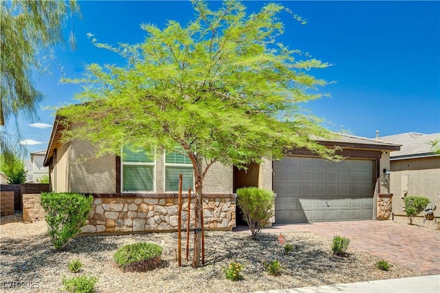 138 Red Sandstone Ave, North Las Vegas, NV 89031 - view of front of house featuring stone siding, decorative driveway, stucco siding, and an attached garage