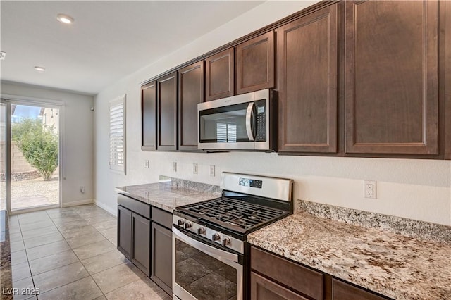 138 Red Sandstone Ave, North Las Vegas, NV 89031 - kitchen with stainless steel appliances, dark brown cabinets, light stone counters, recessed lighting, and light tile patterned floors