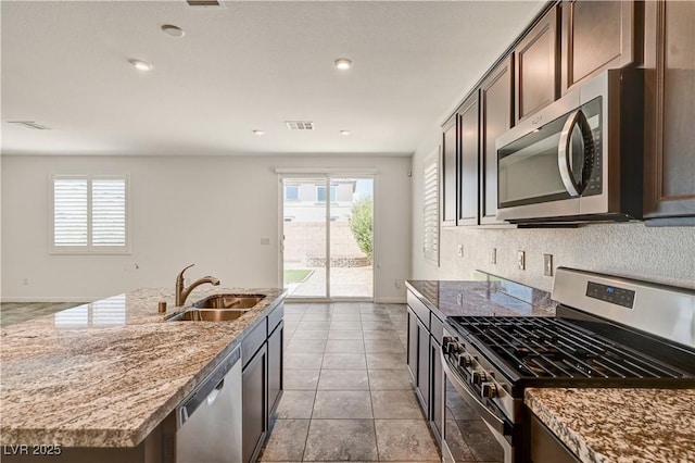 138 Red Sandstone Ave, North Las Vegas, NV 89031 - kitchen featuring stainless steel appliances, healthy amount of natural light, light stone countertops, an island with sink, and recessed lighting