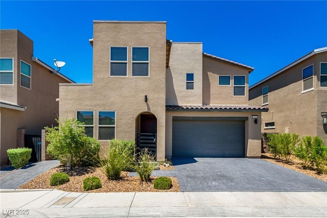 3244 Timorasso Ave, Henderson, NV 89044 - mediterranean / spanish house featuring stucco siding, decorative driveway, an attached garage, and a tile roof
