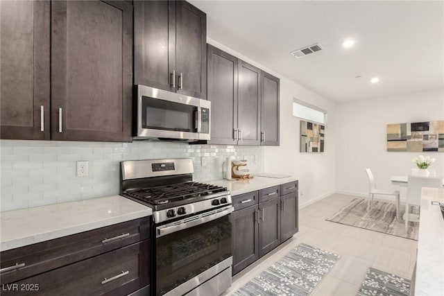 3244 Timorasso Ave, Henderson, NV 89044 - kitchen with appliances with stainless steel finishes, tasteful backsplash, dark brown cabinets, recessed lighting, and light stone countertops