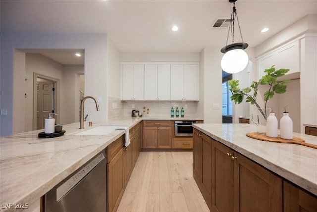 516 Pinnacle Heights Ln, Las Vegas, NV 89144 - kitchen featuring stainless steel appliances, recessed lighting, light stone counters, decorative backsplash, and light wood-style flooring