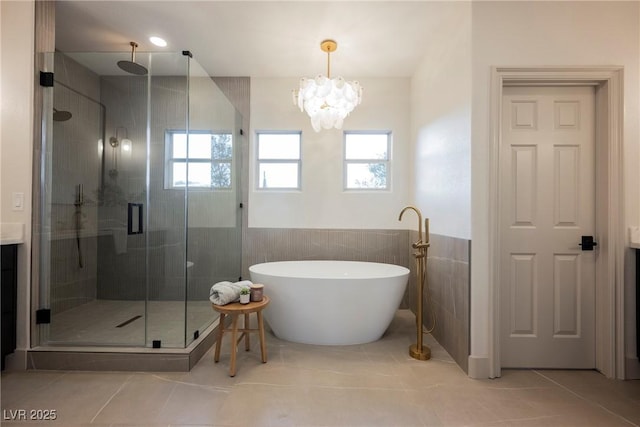 516 Pinnacle Heights Ln, Las Vegas, NV 89144 - bathroom featuring a shower stall, a freestanding bath, a chandelier, tile patterned floors, and a wainscoted wall