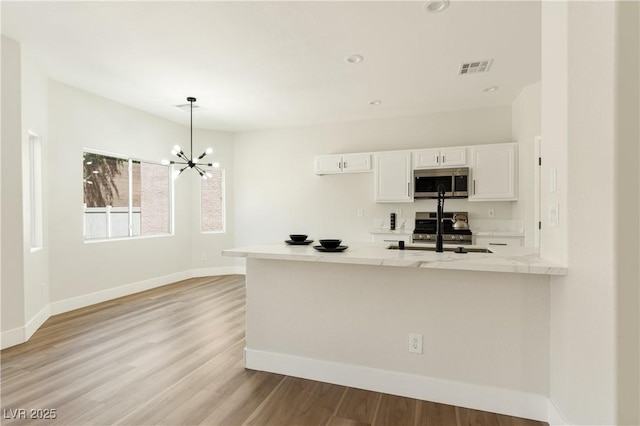 9349 Lakefront Color St, Las Vegas, NV 89178 - kitchen with stainless steel microwave, stove, white cabinets, light countertops, and recessed lighting