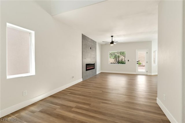 9349 Lakefront Color St, Las Vegas, NV 89178 - unfurnished living room featuring a ceiling fan, a fireplace, and wood finished floors