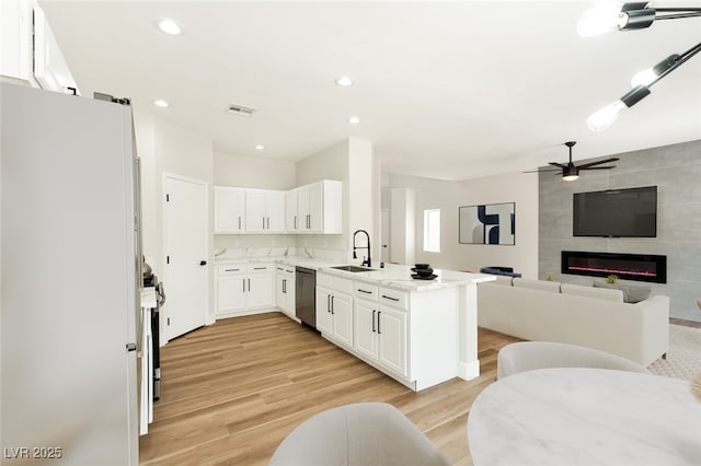 9349 Lakefront Color St, Las Vegas, NV 89178 - kitchen featuring appliances with stainless steel finishes, light wood-type flooring, open floor plan, ceiling fan, and white cabinetry