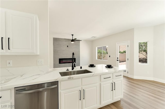 9349 Lakefront Color St, Las Vegas, NV 89178 - kitchen featuring dishwasher, a peninsula, ceiling fan, light wood finished floors, and a fireplace