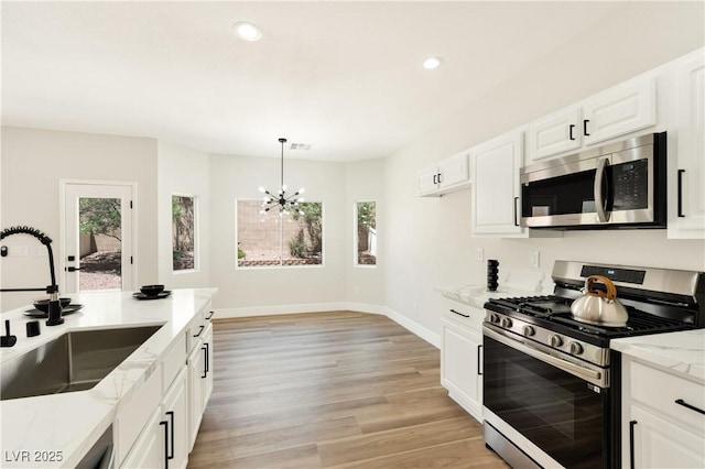 9349 Lakefront Color St, Las Vegas, NV 89178 - kitchen with stainless steel appliances, a chandelier, recessed lighting, light stone countertops, and light wood-style flooring